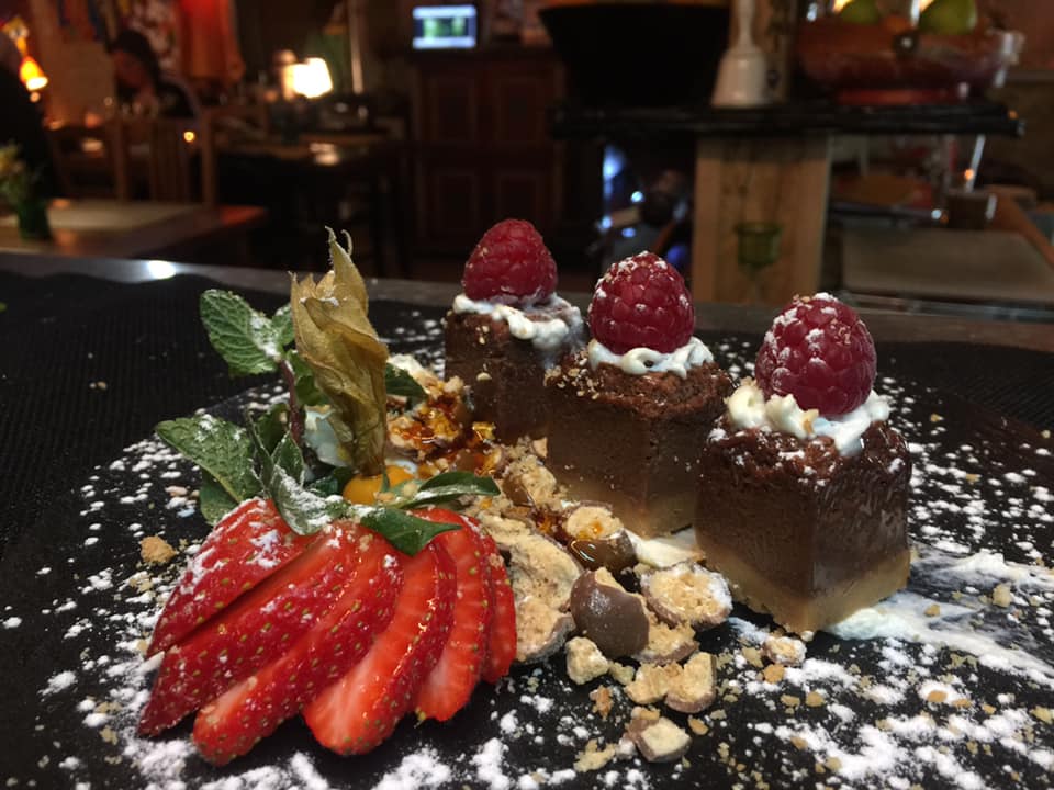 Exterior noturno com neon laranja e vegetação